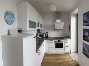 黑尔戈兰岛Tor zum Meer的厨房配有白色橱柜和台面