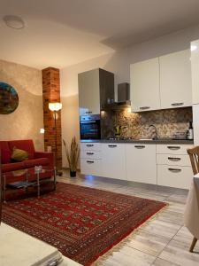 普拉Apartman "Almond house 2"的厨房配有白色橱柜和红色沙发