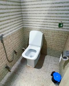 范兰德凡Laxmi Dormitory的浴室位于隔间内,设有白色卫生间。