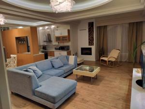 纳夫普利翁Achilles Apartment的客厅配有蓝色的沙发和桌子