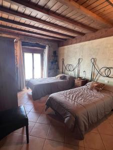 阿尔玛萨Hotel rural Casa la Juana的一间卧室设有两张床和窗户。