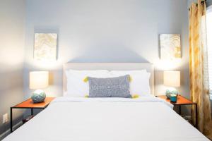 长滩Apartment Located in Historic District Mins to Downtown, Beaches & Convention Center的一间卧室配有一张带两盏灯的大型白色床。