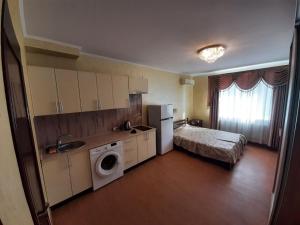敖德萨蒙特利尔宾馆的一个带水槽的厨房和一张位于客房内的床