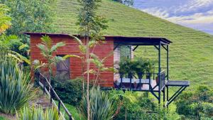 LlanitosGlamping Ocaso的一座带门廊的草屋顶的小房子