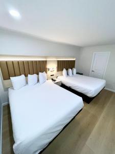 旧金山弗朗西斯科湾旅馆的配有白色床单的酒店客房内的两张床