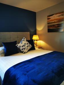 Lissadell海洋高地住宿加早餐旅馆的一间卧室配有一张带蓝色棉被的大床