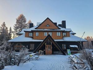 乌斯特龙SCHRONISKO GOŚCINIEC RÓWNICA的一座大木屋,地面上积雪