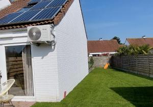 布列登Salty - Vakantiehuisje op de grens van Bredene-De Haan的房屋的一侧设有太阳能电池板