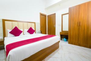马图拉Hotel Superhouse by Wisdom Madhav的一间卧室配有一张带红色枕头的大床
