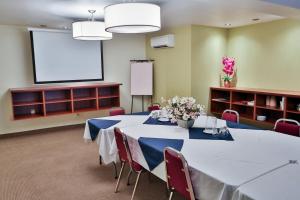 圣索弗尔-德斯蒙特凡尔赛酒店的一间会议室,配有桌子和投影屏幕