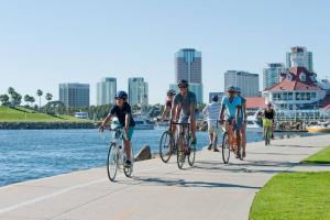 长滩Spacious Home Close to Downtown Long Beach & Convention Ctr的一群人骑着自行车在水边的人行道上