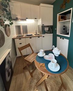 瓦戈兰斯The Tiny home avec jacuzzi 5 min du lac du Bourget 10 min d Aix les bains et Chambery的一间小厨房,内设桌椅