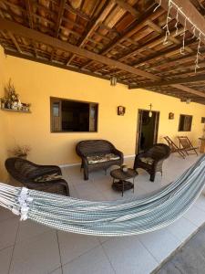 拉巴拉德纳圣安东尼奥Lar da paz - Ilha da Crôa的庭院设有吊床、椅子和电视。