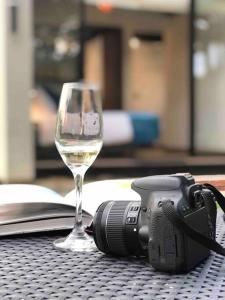 拉维加Luxury Glamping - Tiny House al natural的一杯葡萄酒和一张桌子上的相机