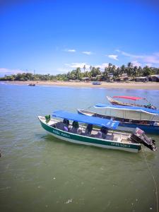 Playa LadrillerosApartamento Playa Juanchaco的两艘船停靠在海滩附近的水面上