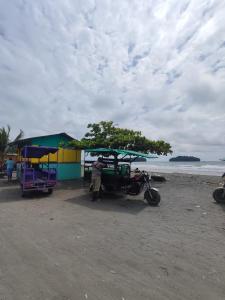 Playa LadrillerosApartamento Playa Juanchaco的站在海滩上车厢旁的人