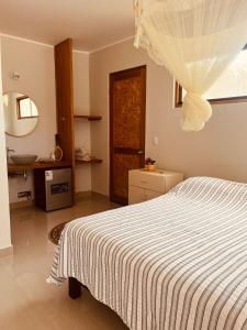 曼克拉La Nómada Digital - Máncora Playa & Piscina的卧室配有白色的床和镜子