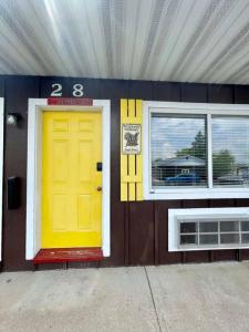 威斯康星拉皮兹#28 Snooze的一座建筑,设有黄色的门和两扇窗户