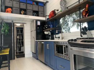克莱蒙Modern, pet friendly tiny house, No extra fees!的厨房配有蓝色橱柜和炉灶。