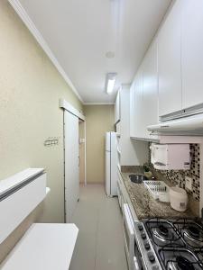 瓜鲁雅Sol & Nascente的厨房配有白色橱柜和炉灶。