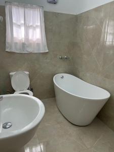 SavanetaLa Villas at Pos Chiquito Caribbean Paradise in Aruba的浴室配有白色浴缸和卫生间。