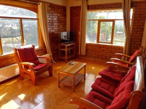 科伊艾科Casa Cerro Divisadero的客厅配有沙发、椅子和电视