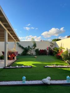 SavanetaLa Villas at Pos Chiquito Caribbean Paradise in Aruba的绿草花园和建筑