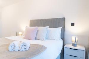 伯明翰Apex Lofts Suite - Modern 2 bed with rooftop terrace的一间卧室配有一张带白色毛巾的床