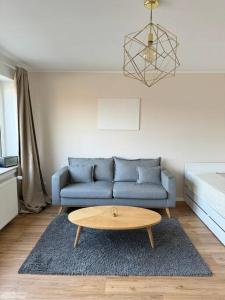 奥伯豪森Sanierte 2 Zimmer Wohnung am CentrO in Oberhausen的客厅配有蓝色的沙发和茶几