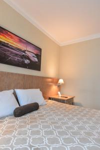 圣保罗Premium room Berrini的一间卧室配有一张大床,墙上挂着一幅大画