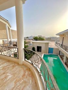 努瓦克肖特wonderful and distinctive villa that you will love的享有游泳池景致的阳台