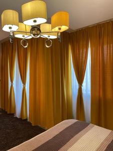 波亚纳布拉索夫Luxury Apartment Silver Mountain Vue的一间卧室配有橙色窗帘和一张带天花板的床