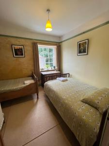 卡斯尔顿Torside Holiday Cottage的一间卧室设有两张床、一张桌子和一个窗口。