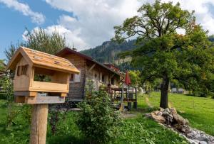 韦尔塔赫Tinyhouse Momente Chalet als Rückzugsort für Naturliebhaber im Oberallgäu的屋前木杆上的木鸟屋