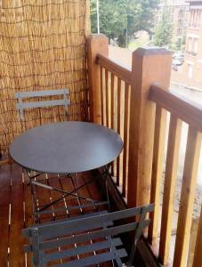 让蒂伊Appartement Charme petite terrasse à 400m de Paris的阳台的桌子和长凳