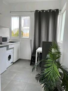 让蒂伊Appartement Charme petite terrasse à 400m de Paris的一间带桌子的客厅和一间厨房