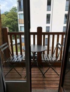 让蒂伊Appartement Charme petite terrasse à 400m de Paris的阳台配有一张桌子和两把椅子