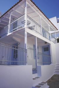 斯基亚索斯镇The Guest House的白色的房子,阳台带有蓝色栏杆