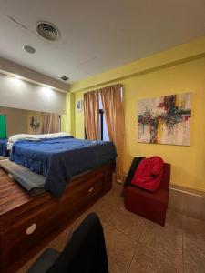 布宜诺斯艾利斯Aparta Hotel的一间卧室配有一张床和一把椅子