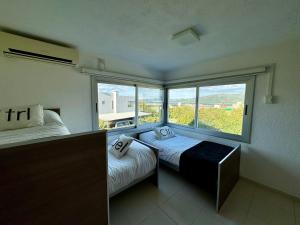 波特雷罗德加雷Casa Calma Puerto del Aguila的一间卧室设有两张床和大窗户