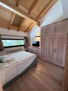 摩德纳迪-坎皮格里奥CAMPIGLIO Panorama sul Brenta的一间卧室配有一张大床和木制橱柜。