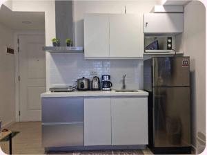 马尼拉Azure urban residences 1BR Unit fits max 3 persons的厨房配有白色橱柜和不锈钢冰箱