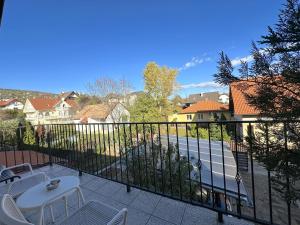 布达厄尔什Rozsé Apartman-tetőtér的阳台配有桌椅,享有街道的景色。