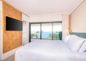 圣丹尼斯Radisson Hotel Saint Denis, La Reunion的卧室设有一张大白色的床和大窗户