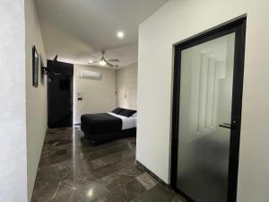 梅里达Hotel Suites La Negra的一间卧室配有一张床和一个带镜子的门