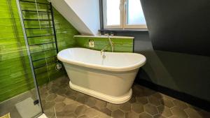 布莱顿霍夫The Coach House - Your luxury private Brighton getaway with private parking的带浴缸的浴室和绿色的墙壁
