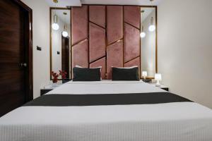 班加罗尔Astra Hotels & Suites - Koramangala的卧室配有一张白色大床和木制床头板