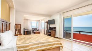 罗萨里托新巴哈港酒店及别墅的一间卧室配有一张床,享有海景