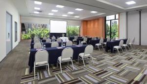 瓜达拉哈拉Hotel Guadalajara Country Club by HNF的一间会议室,配有桌椅和屏幕