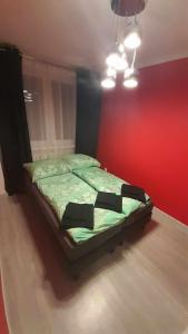 科沙林Mieszkanie osiedle Północ的红色墙壁的房间里一张床位